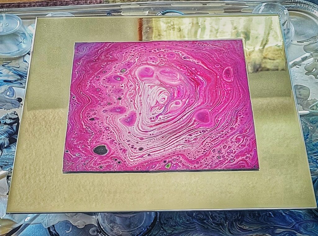 Square 12 by 12-inch glass mirror with pink and white fluid pour in the center.