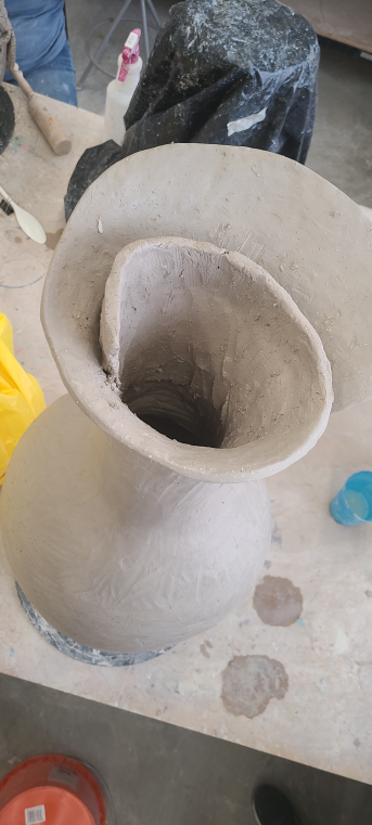 The fluted top of the vase forming.